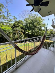 a hammock on the balcony of a house at Refugio Caribeño in Puerto Limón