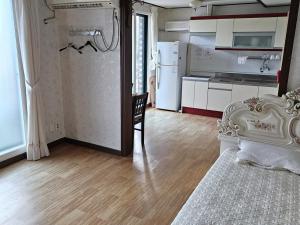 Habitación con cama y cocina con nevera. en Donghae Dream Beach, en Donghae