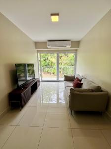 a living room with a couch and a flat screen tv at Refugio Caribeño in Puerto Limón