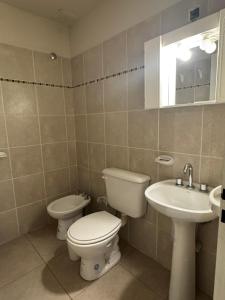 a bathroom with a toilet and a sink at Duplex premium in La Porteña