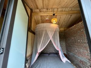 a canopy in a room with a brick wall at Sapa Hillcrest homestay in Lao Cai