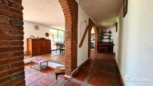 a living room with a brick wall and a brick floor at Finca Taino. Hermosa casa con alberca in Jiutepec