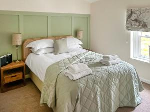 a bedroom with a bed with towels on it at Tiddles Corner in Braunston
