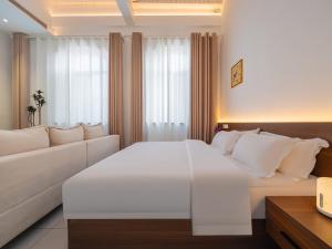 a bedroom with a large white bed and a couch at JOYSEA HUT in Yantai +87 photos