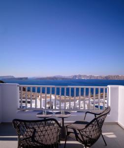 a table and chairs on a balcony with a view of the ocean at Exquisite Santorini Villa Villa Luna 3 Bedrooms Breathtaking Sea Views And Private Pool Akrotiri in Akrotiri