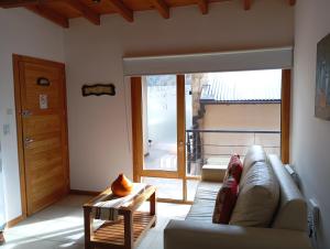 una sala de estar con un sofá y una mesa en Departamento El Descanso Ruka IV, en San Martín de los Andes