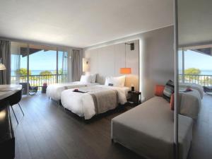 a hotel room with two beds and a balcony at Tahiti Lagoon Resort in Punaauia +39 photos