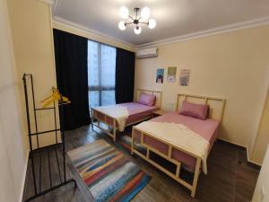 a room with two beds and a window at Comfort Plaza A in Cairo