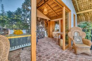 an outdoor patio with two chairs and a table at NEW! Jacuzzi, lake-access luxury in San Marcos La Laguna