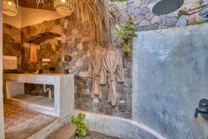 a bathroom with a stone wall with a fireplace at NEW! Jacuzzi, lake-access luxury in San Marcos La Laguna +30 photos