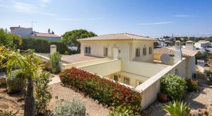 a large white house with a lot of flowers at Villa Povo Do Burro, Beautiful And Elegant Villa, Few Minutes Walk To Resort in Carvoeiro
