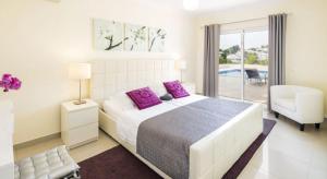 a bedroom with a large bed with purple pillows at Villa Povo Do Burro, Beautiful And Elegant Villa, Few Minutes Walk To Resort in Carvoeiro +24 photos