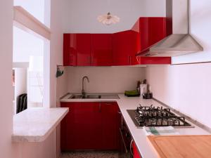 ポルト・サン・ジョルジョにあるLepanto 14のキッチン(赤いキャビネット、シンク付)