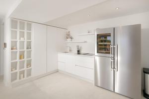 a kitchen with white cabinets and a stainless steel refrigerator at Beautiful Hvar Villa 4 Bedrooms Villa Hvar Majestic Resort Centre Location & Wonderful Sea Views in Hvar