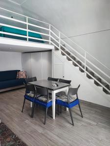 una sala da pranzo con tavolo, sedie e scale di La Perla del Borgo Casa Vener a Vieste