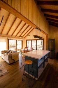 a kitchen and living room with a table and chairs at Casa Las Raíces - Relajo con tinaja y vista al volcán, a minutos de Corralco in Malalcahuello
