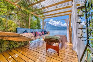 a hammock on a deck with a view of the water at Magical lakeview Casita, swim dock, sauna, kitchen in San Marcos La Laguna +10 photos
