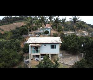 a white house on top of a hill with trees at Casa Bello Monte in Venda Nova do Imigrante
