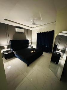 un salon avec un canapé noir et une table dans l'établissement One bed comfortable luxury apartment, à Dargai