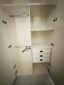 un dressing avec des armoires et des tiroirs blancs dans l'établissement One bed comfortable luxury apartment, à Dargai