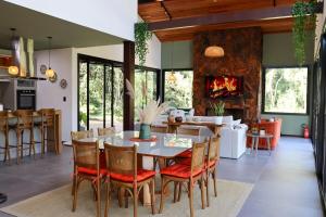Un comedor con mesa y sillas y chimenea. en Casa Despertar na Montanha Urubici, en Urubici
