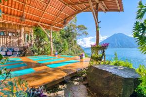 a group of yoga mats on a wooden table next to the water at Lake view paradise- waterfall, swim dock, kitchen in San Marcos La Laguna