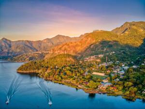 an island in the middle of a lake with mountains at Lake view paradise- waterfall, swim dock, kitchen in San Marcos La Laguna +10 photos