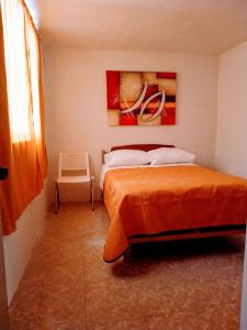 a bedroom with a bed and a painting on the wall at Casa SUR in Colonia de Venado