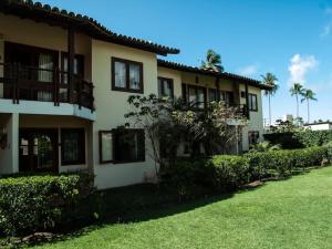 a building with a grass yard in front of it at Condomínio Vila Aurora in Porto Seguro