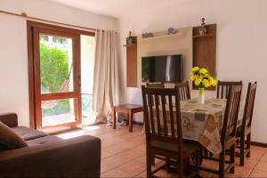 a living room with a table and chairs and a couch at Condomínio Vila Aurora in Porto Seguro