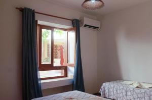 a bedroom with two beds and a window at Condomínio Vila Aurora in Porto Seguro +38 photos