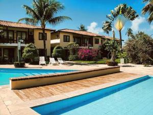 a house with a swimming pool in front of a house at Condomínio Vila Aurora in Porto Seguro