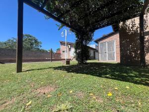 a building with a tree in the middle of a yard at Relajate en Suipacha!! in Suipacha
