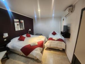 two beds in a room with lights on the wall at Las Marías in Chilecito