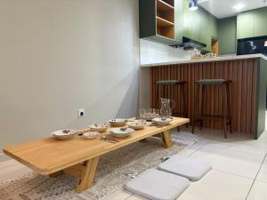 a wooden table with bowls and plates on it in a kitchen at Gaia Residences by Plush in Rawang