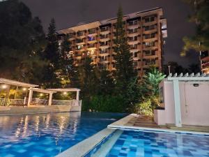 a hotel with a swimming pool in front of a building at Camella Northpoint in Davao City