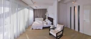 ein Schlafzimmer mit weißen Vorhängen sowie einem Bett und einem Stuhl in der Unterkunft Stunning Brac Villa 5 Bedrooms Villa Selca Brac 5 Metres To The Beach Private Swimming Pool Selca in Selca