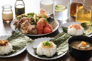 a table topped with plates of food and bowls of soup at Via Inn Shin Osaka in Osaka +20 photos