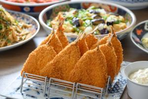 a plate of food on a table with plates of food at Via Inn Shin Osaka in Osaka