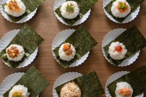 a wooden table topped with green food in paper cups at Via Inn Shin Osaka in Osaka