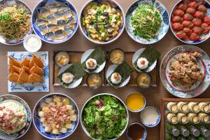 a table with plates of food and bowls of food at Via Inn Shin Osaka in Osaka