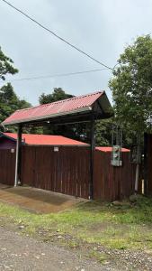a building with a red roof and a wooden fence at The La Casa de Rum & Drum - Suite A in Monteverde Costa Rica