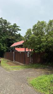 a building with a red roof with a fence at The La Casa de Rum & Drum - Suite A in Monteverde Costa Rica