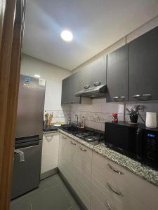 a kitchen with a refrigerator and a stove top oven at Appartement avec une chambre et jardin in Bin Rhilouf