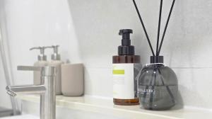 een badkamerwastafel met daarin een fles zeep en stokjes bij Urban Retreat 3-Min Walk from Achasan Station, 15-Min to Seongsu, Tranquil Space for Relaxation in Seoul +54 foto's