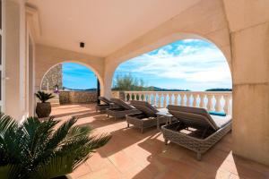 a patio with chairs and a table on a balcony at Dazzling Lozica Villa 5 Bedrooms Villa Pasija Steam Room & Private Plateau Beach in Dubrovnik