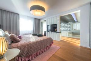 a bedroom with a bed and a flat screen tv at Dazzling Lozica Villa 5 Bedrooms Villa Pasija Steam Room & Private Plateau Beach in Dubrovnik