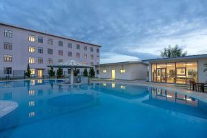 a hotel with a swimming pool in front of a building at Protea Hotel by Marriott Lusaka International Airport in Lusaka