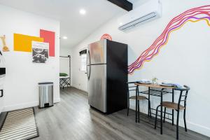 a kitchen with a refrigerator and a table at St Louis Premier Modern Vegas Escape Arts District & Patio in Las Vegas