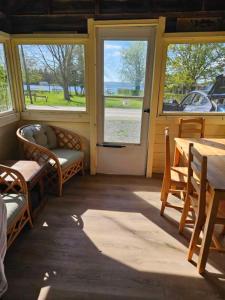 une chambre avec des chaises, une table et des fenêtres dans l'établissement Fun Place with a Sandy Beach for Swimming, Boating & Fishing, Featuring 1 House and 3 Cabins, à Fenelon Falls